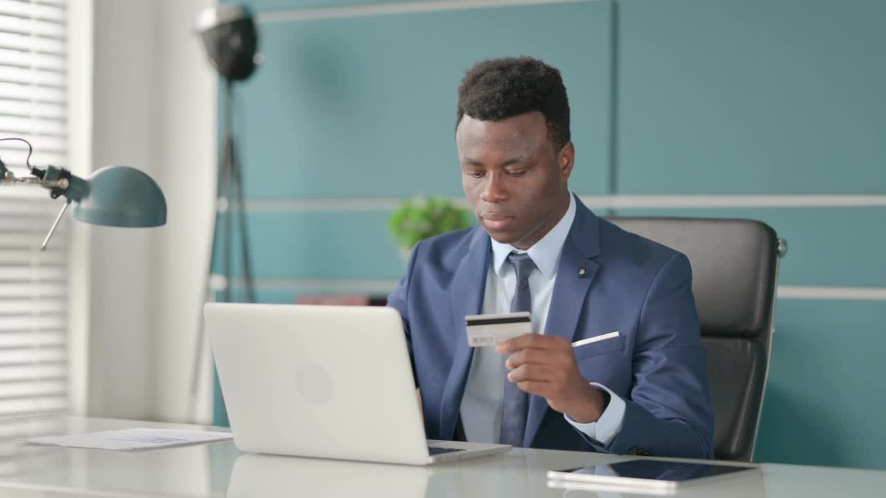 非洲商人在办公室的笔记本电脑上进行在线支付失败视频素材