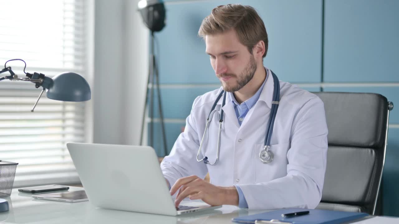 医生在工作时使用笔记本电脑时竖起大拇指视频素材