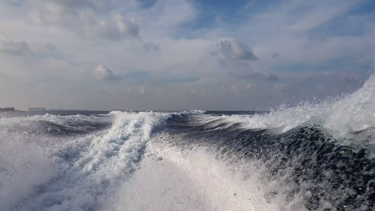 从海面低角度观察汽艇在水中升起的尾流视频素材