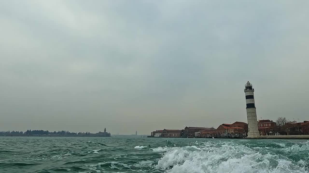 从航行摩托艇上看到的Murano灯塔的低角度水面视图，意大利。慢动作视频素材