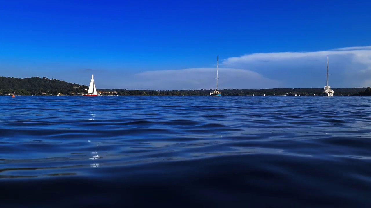 极低的角度，小红船航行在平静的开放的湖水马乔雷湖在意大利视频素材