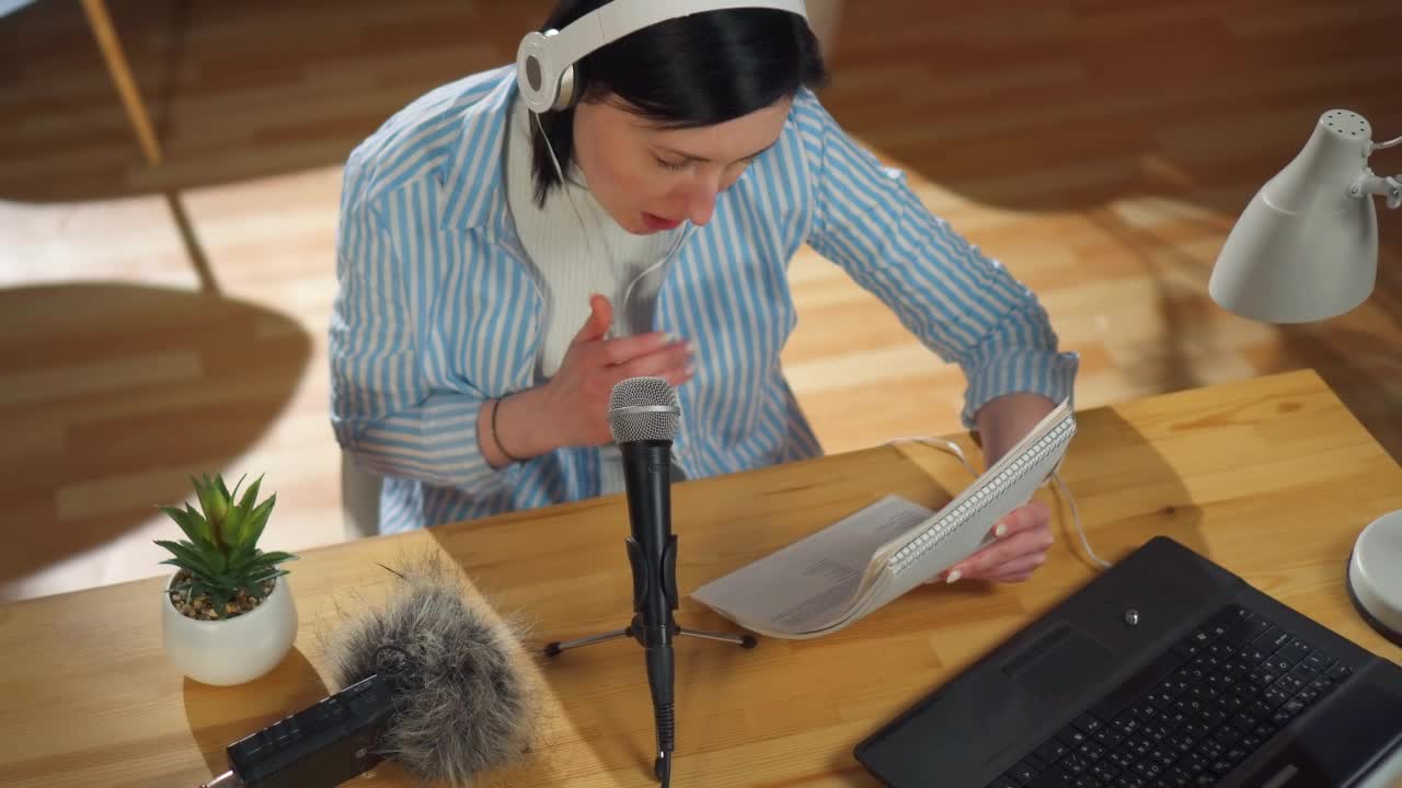 一位女士坐在客厅的桌子前录制播客，俯视图视频下载