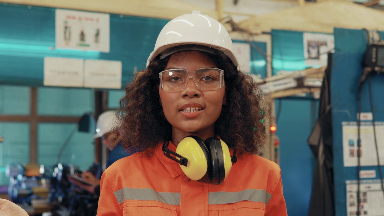 一位女工程师的肖像正在工厂里微笑。视频素材