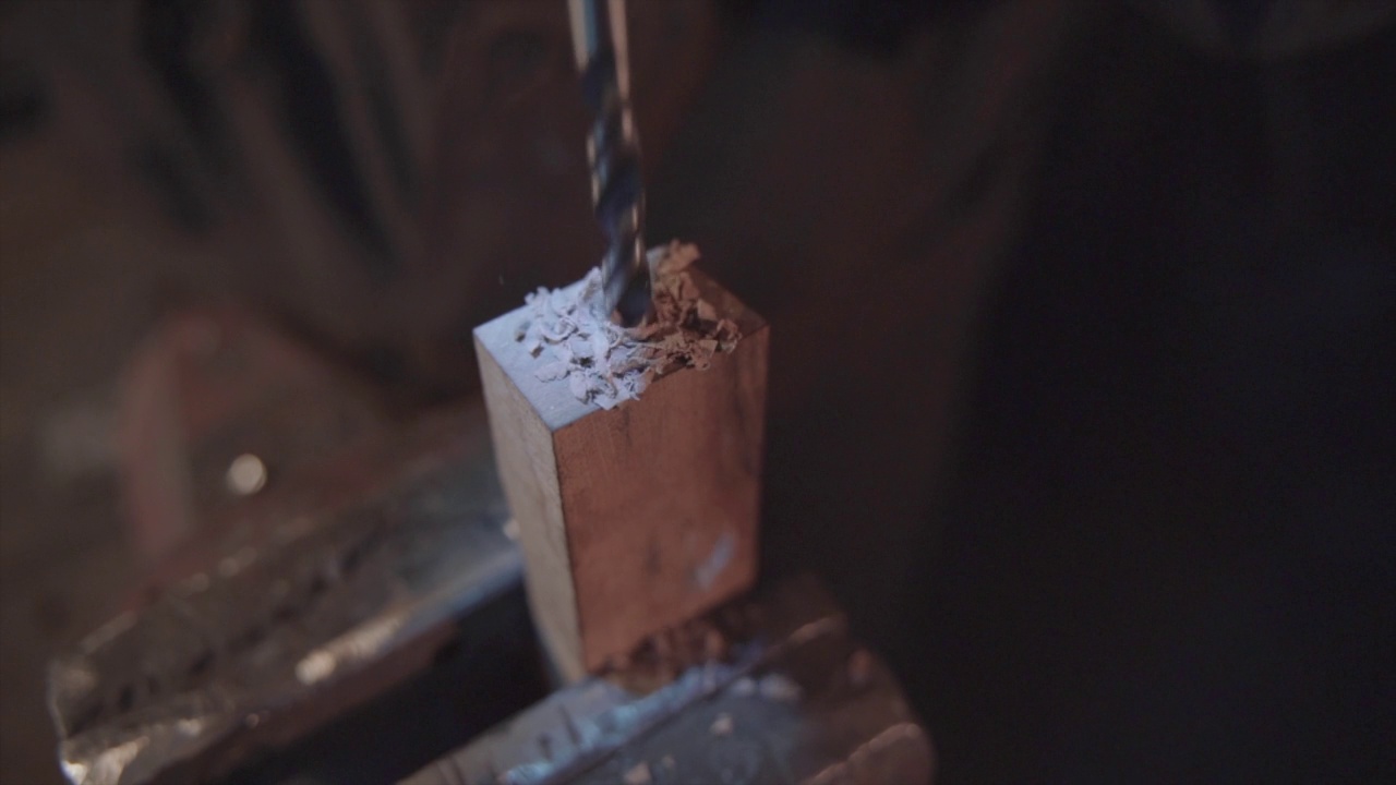 铁匠在木头上钻孔。大马士革钢的刀。视频下载