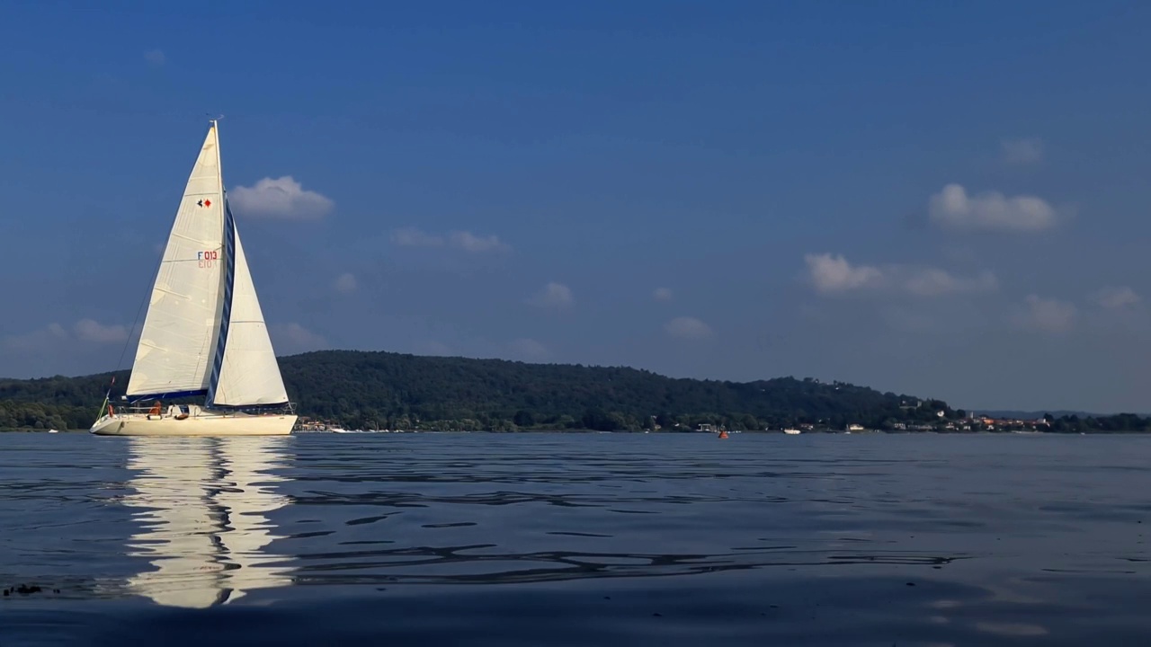 慢动作和低角度的看法小船航行在平静的开放的湖面马乔里湖在意大利视频素材