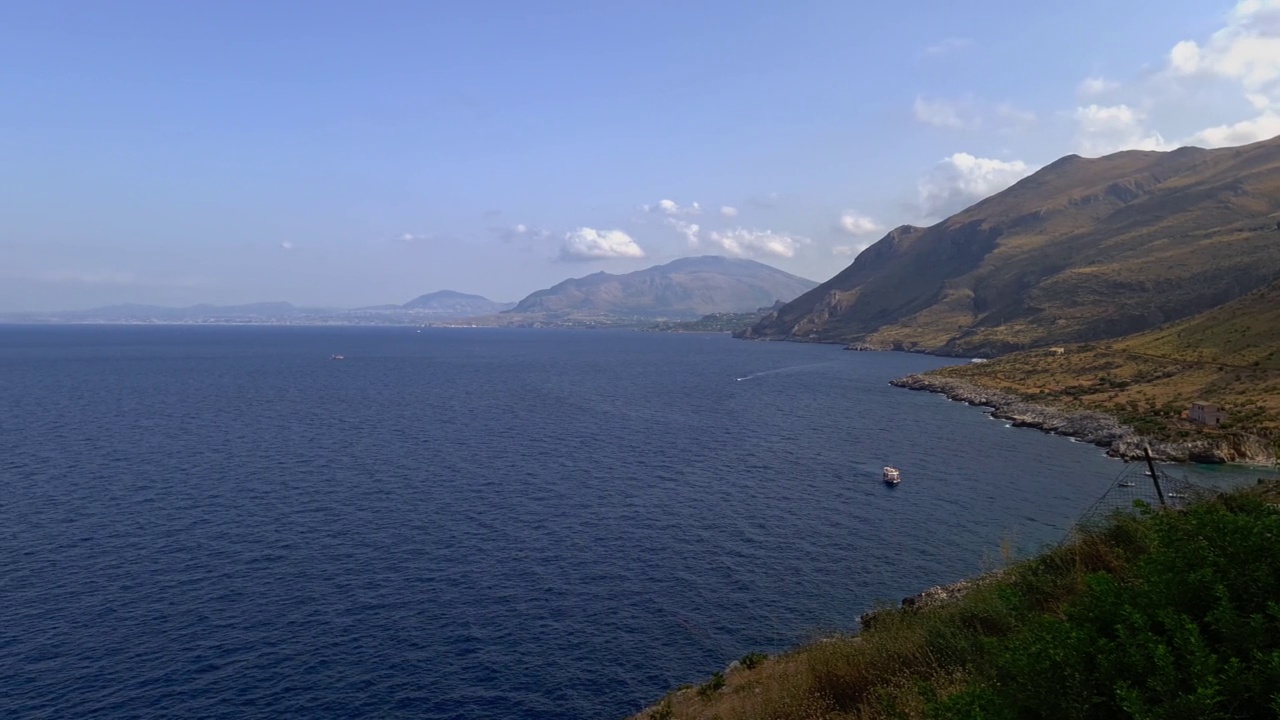 西西里的Riserva dello Zingaro自然保护区的空中摇盘，有山、悬崖、船和海湾。意大利视频素材