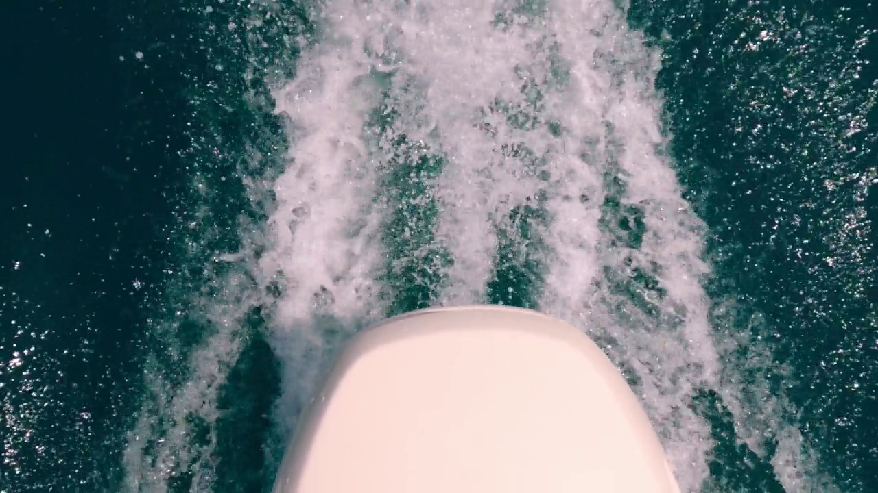 不寻常的独特的大角度的摩托艇发动机离开海水尾流。慢动作视频素材