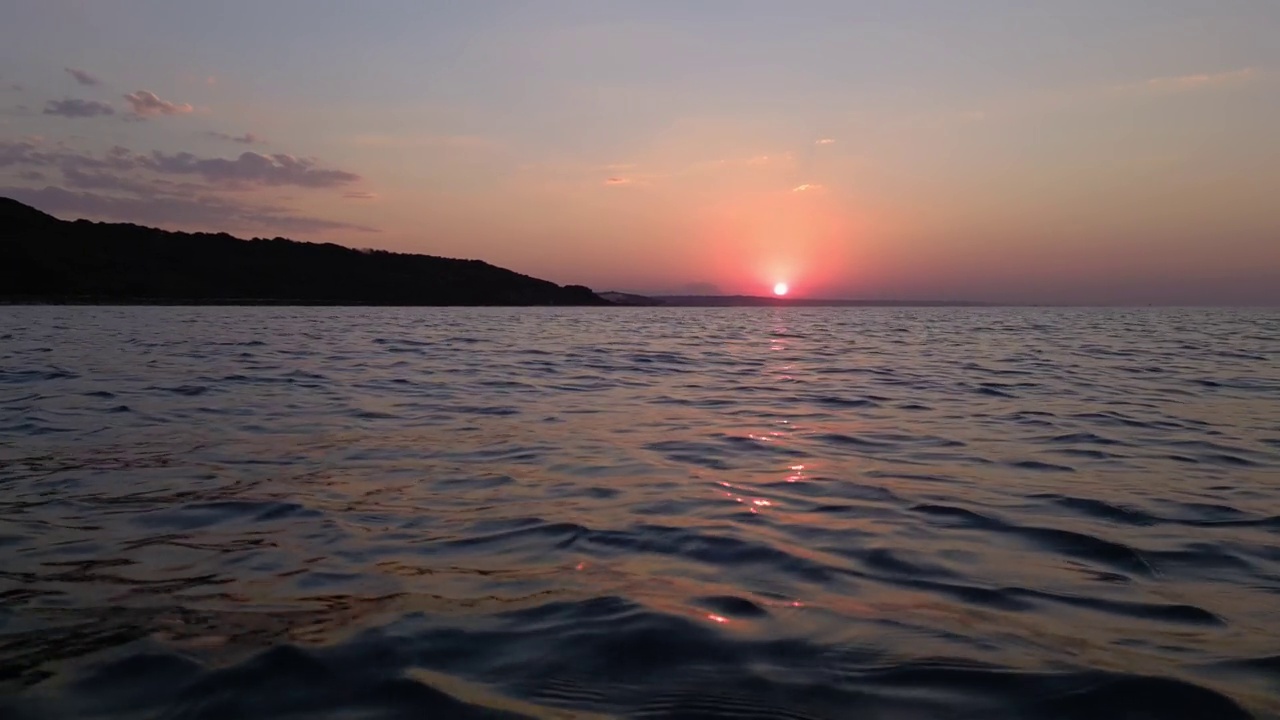 日落时在海面上横移的极低角度。第一人称视角视频素材