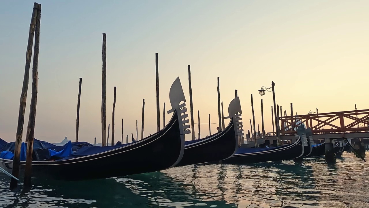 日落时停靠的贡多拉的低角度水面视图，意大利威尼斯视频素材