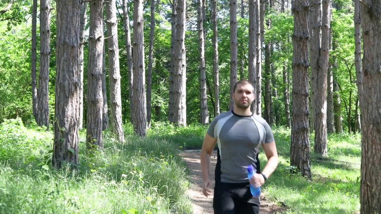 年轻的运动员在森林里跑步视频素材
