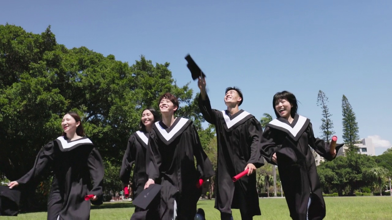 一群快乐的毕业生扔帽子视频素材