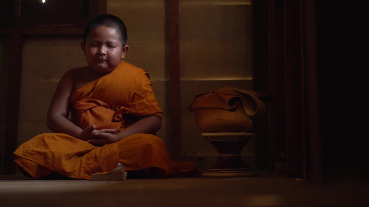 东南亚泰国小和尚在寺院内打坐，传授佛法。年轻的沙弥和尚在寺院里学习。视频素材