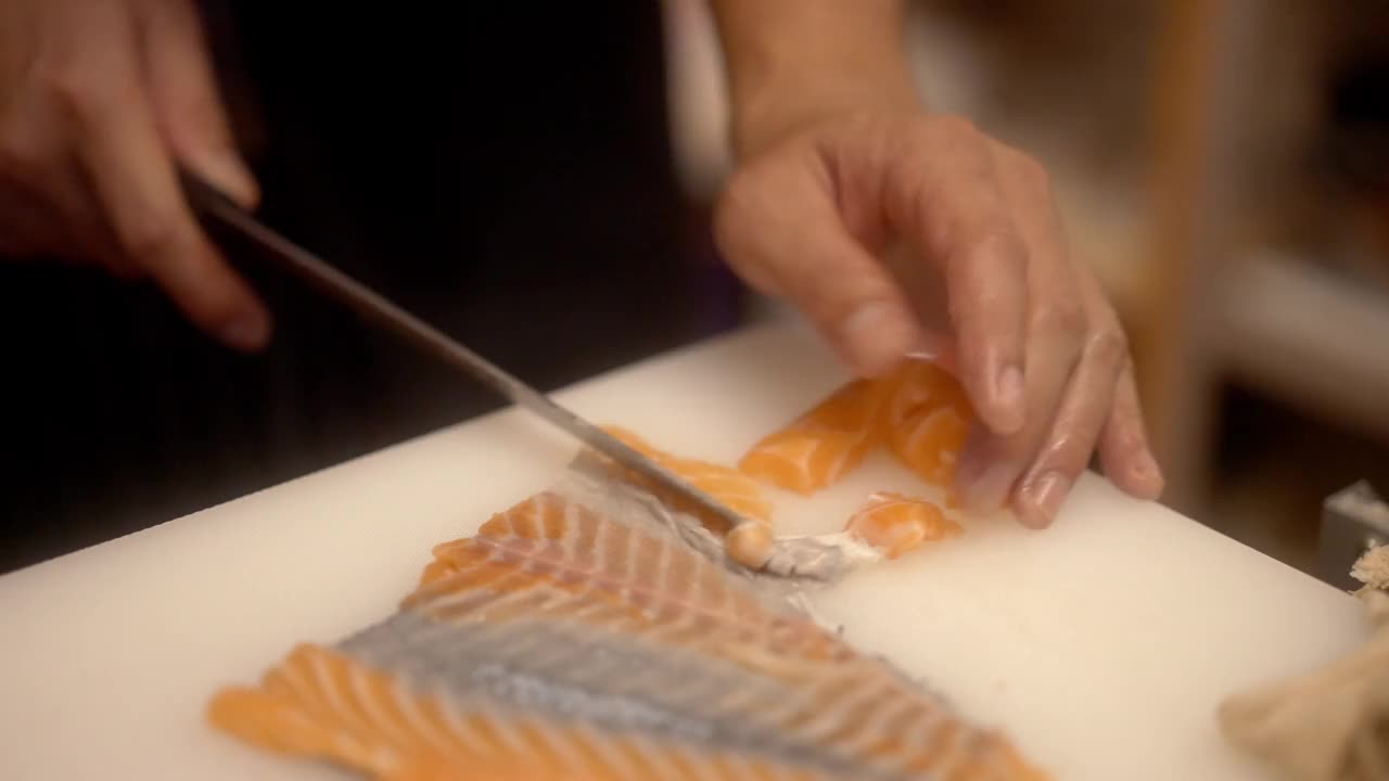日本寿司师傅正准备切片生鱼片为顾客制作寿司的特写镜头视频素材