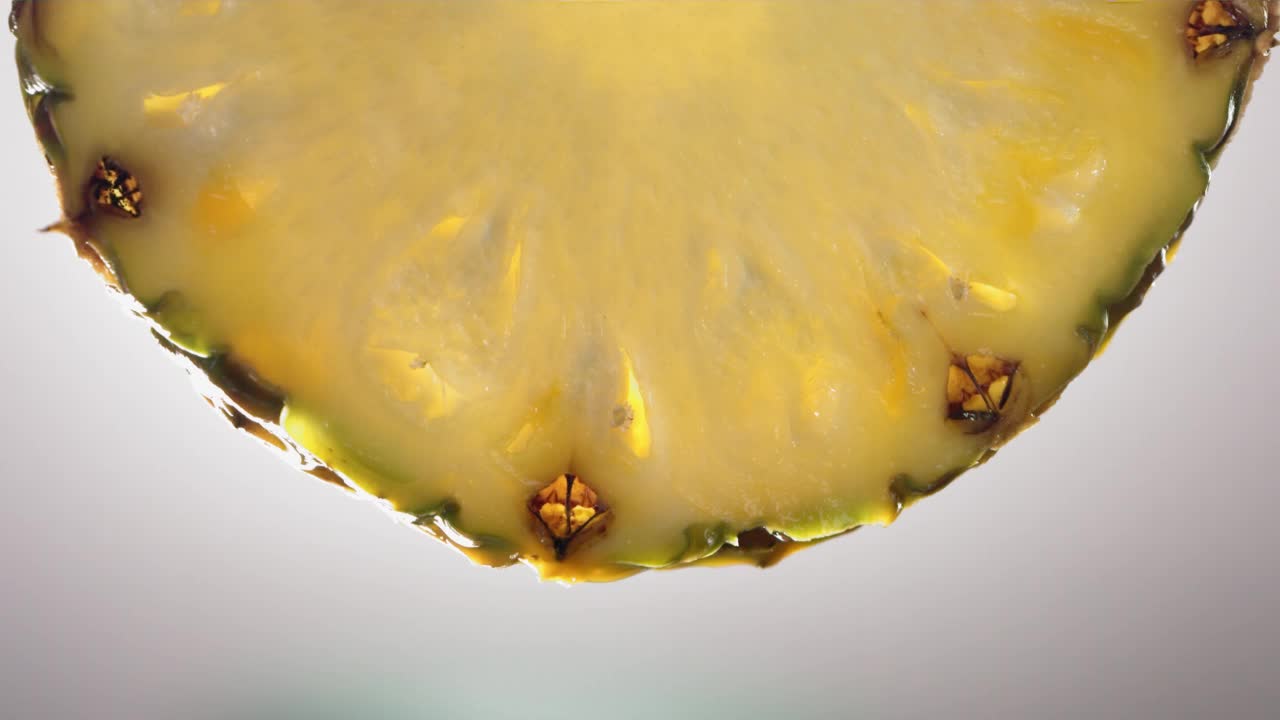 流动的菠萝汁从菠萝片，微距镜头在慢动作视频素材