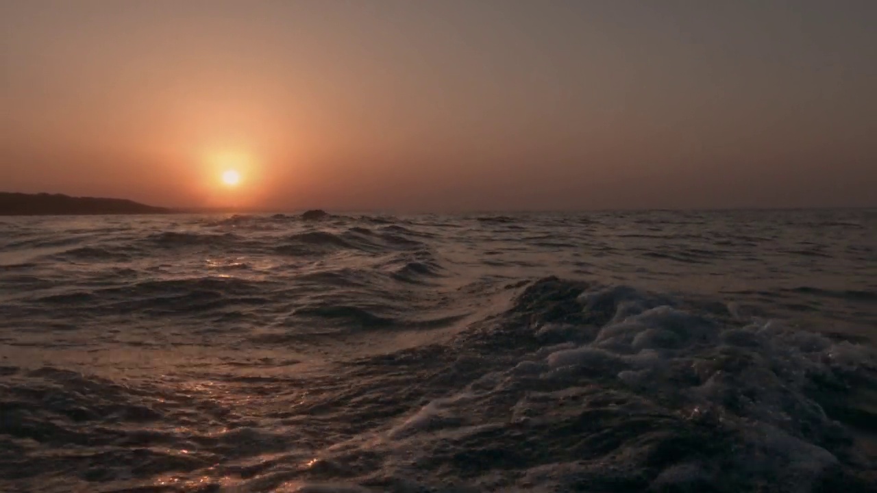 低角海平面pov从帆船航行在海面上向后在金色的日落视频素材