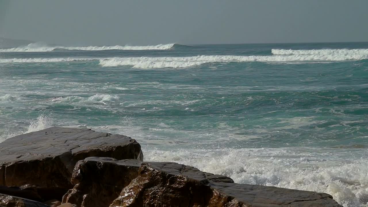 波破碎岩石。海浪的力量。慢动作视频素材