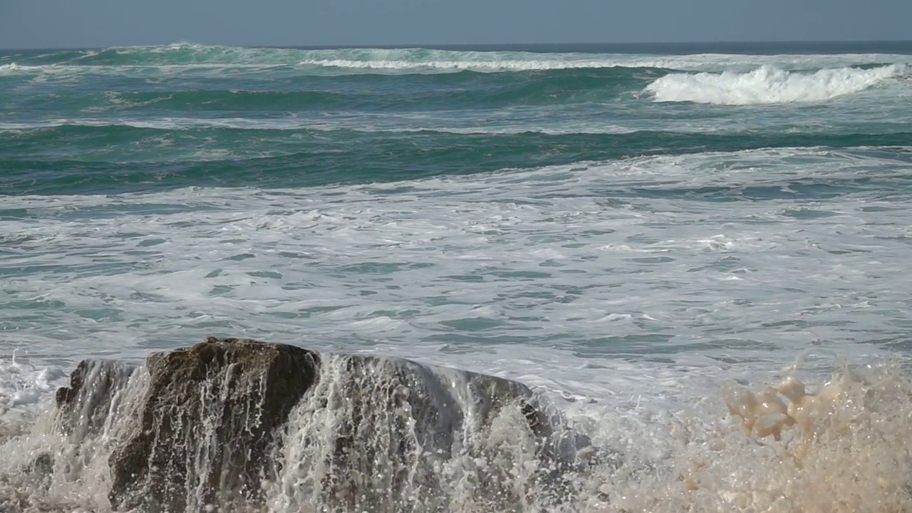 波破碎岩石。波的力量视频素材