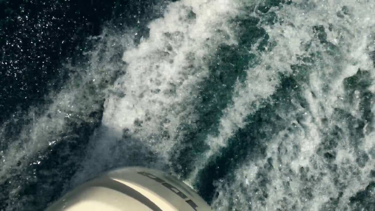 不寻常的大角度pov摩托艇运行引擎留下海水白色泡沫白色尾流视频素材