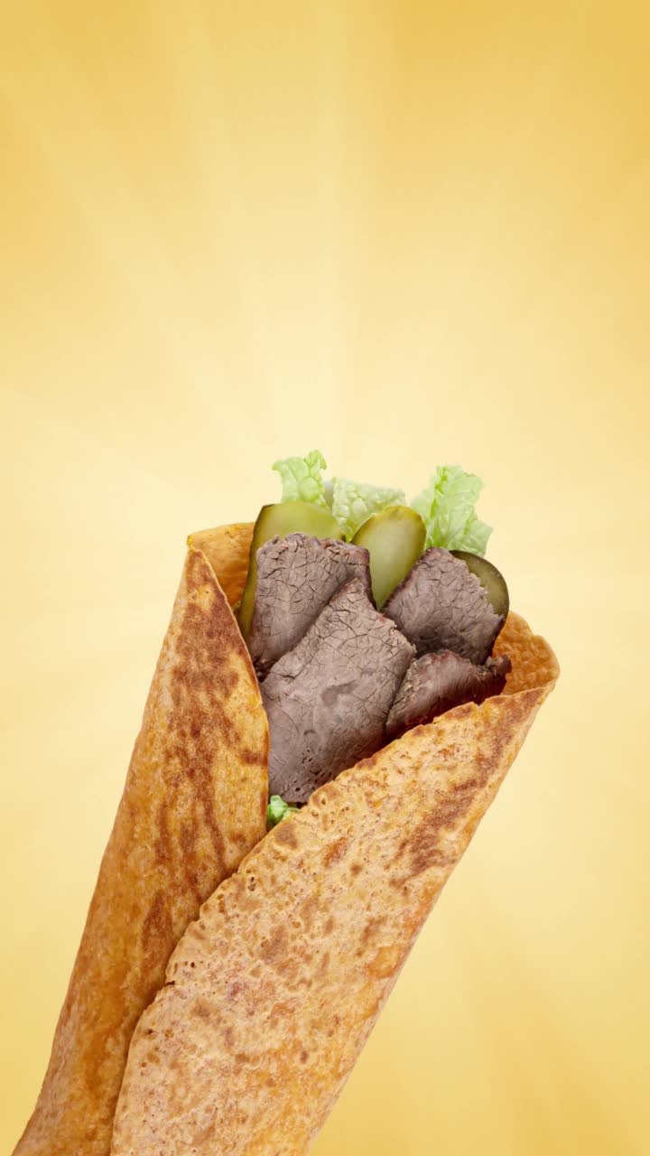 玉米煎饼与烤牛肉，绿色沙拉和蔬菜上面亮黄色的背景，复制空间，垂直的镜头视频下载