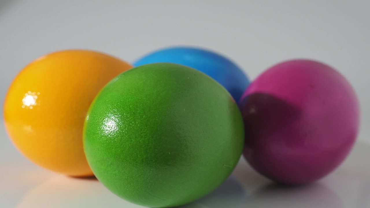 彩色的鸡蛋在白色背景下旋转。画鸡蛋特写。视频下载