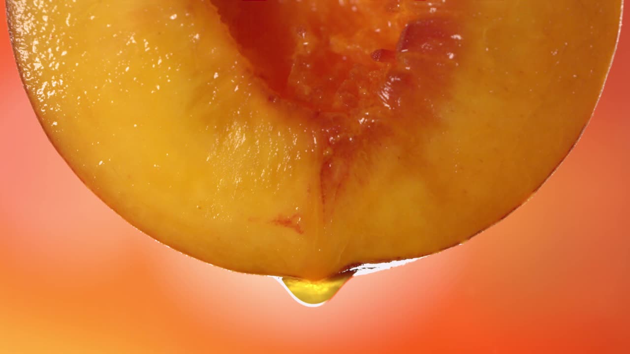 从半桃流动的桃汁的慢动作微距镜头视频素材