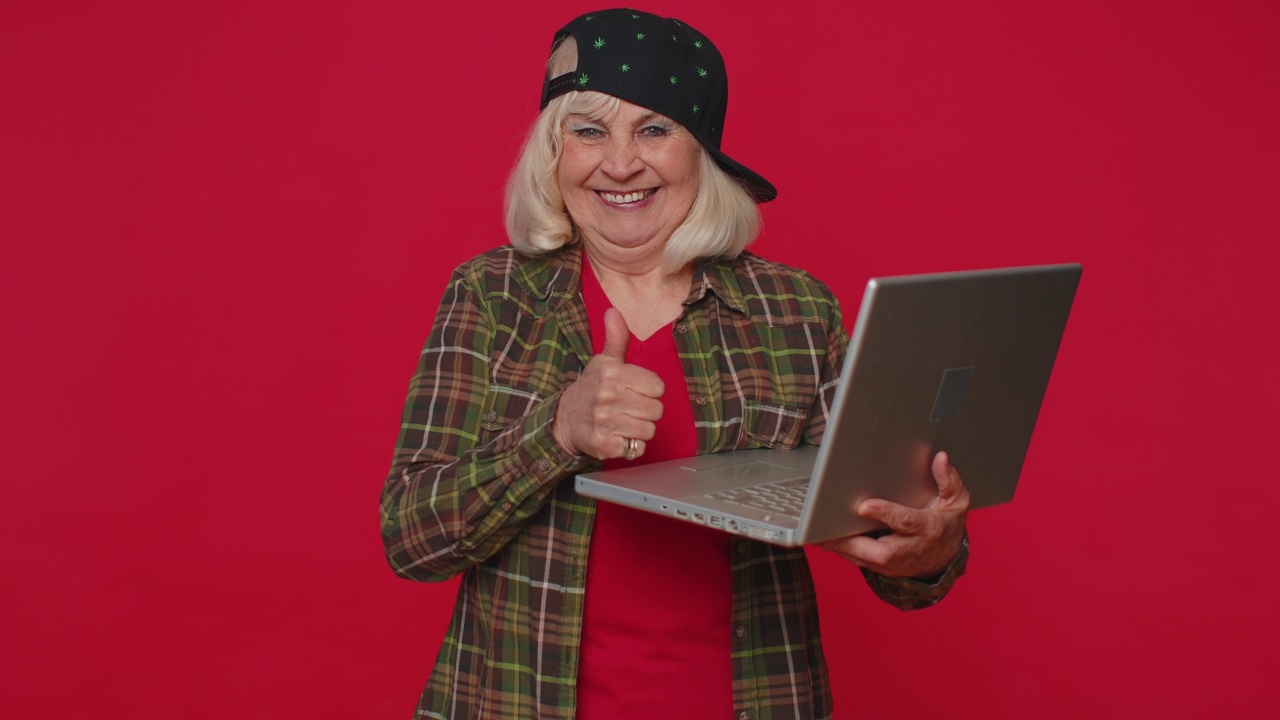 快乐的高级女性在笔记本电脑上打字，在项目上工作，享受结果，赢得彩票视频素材