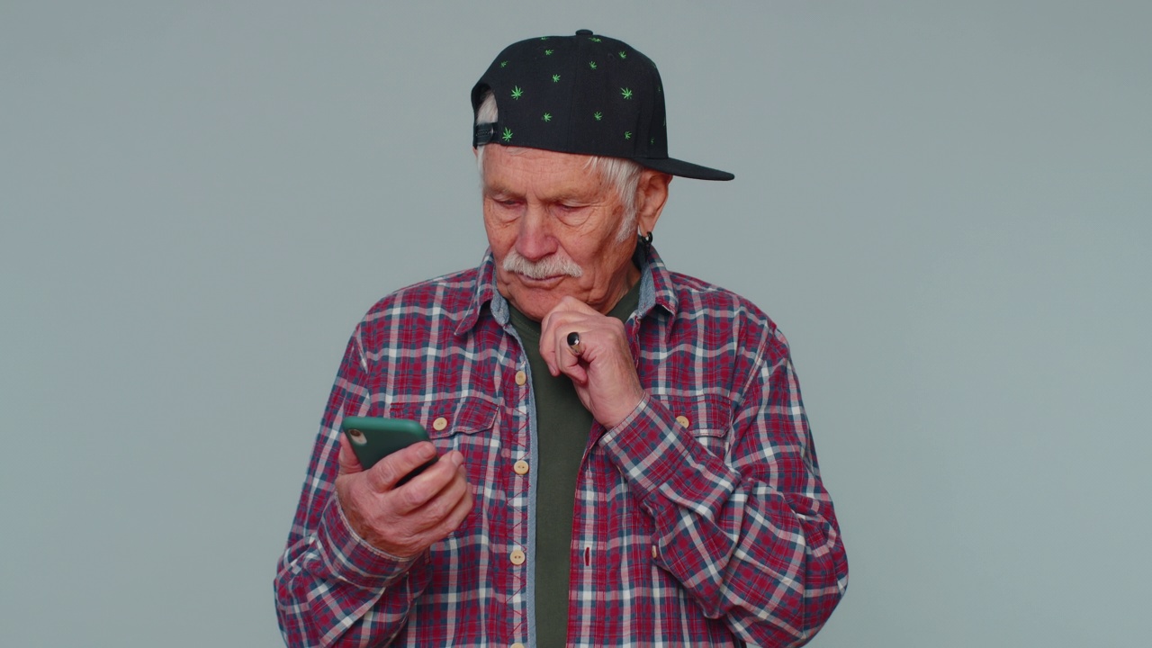 老年男子利用手机打字，在网上发短信，浏览社交网络成瘾视频素材
