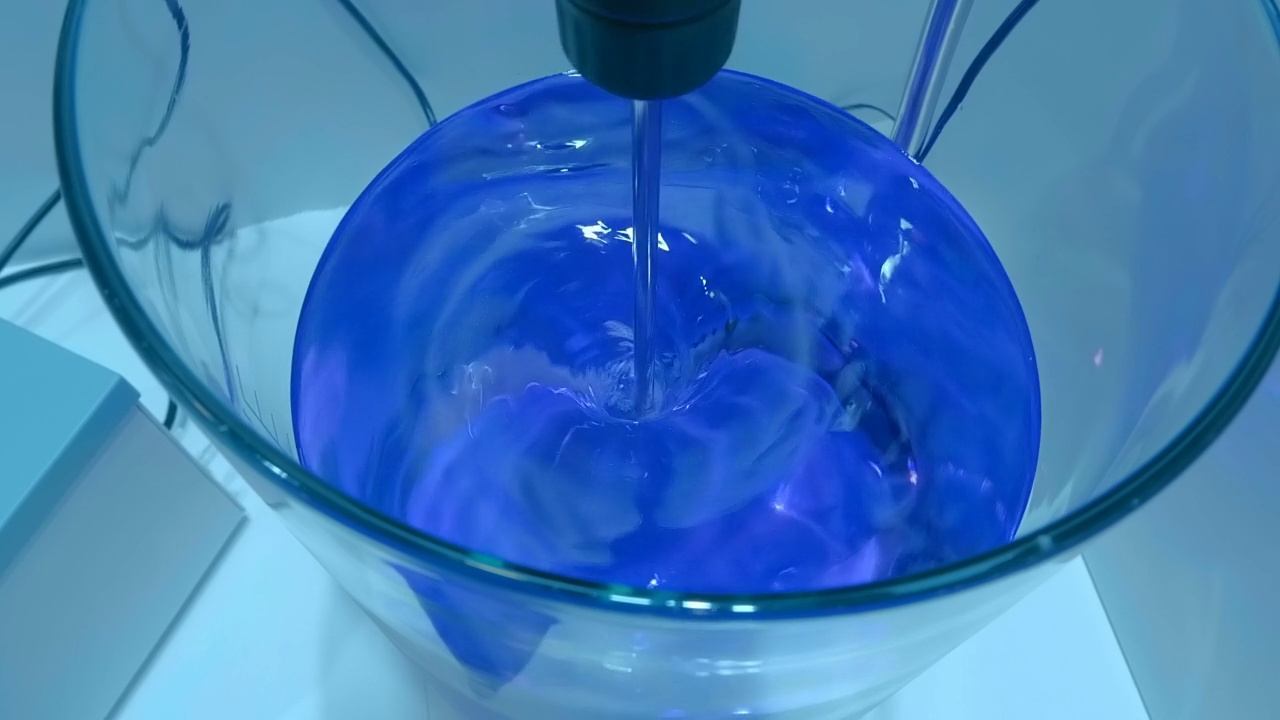 实验室的电动混合器在玻璃容器中混合产品的解决方案视频素材