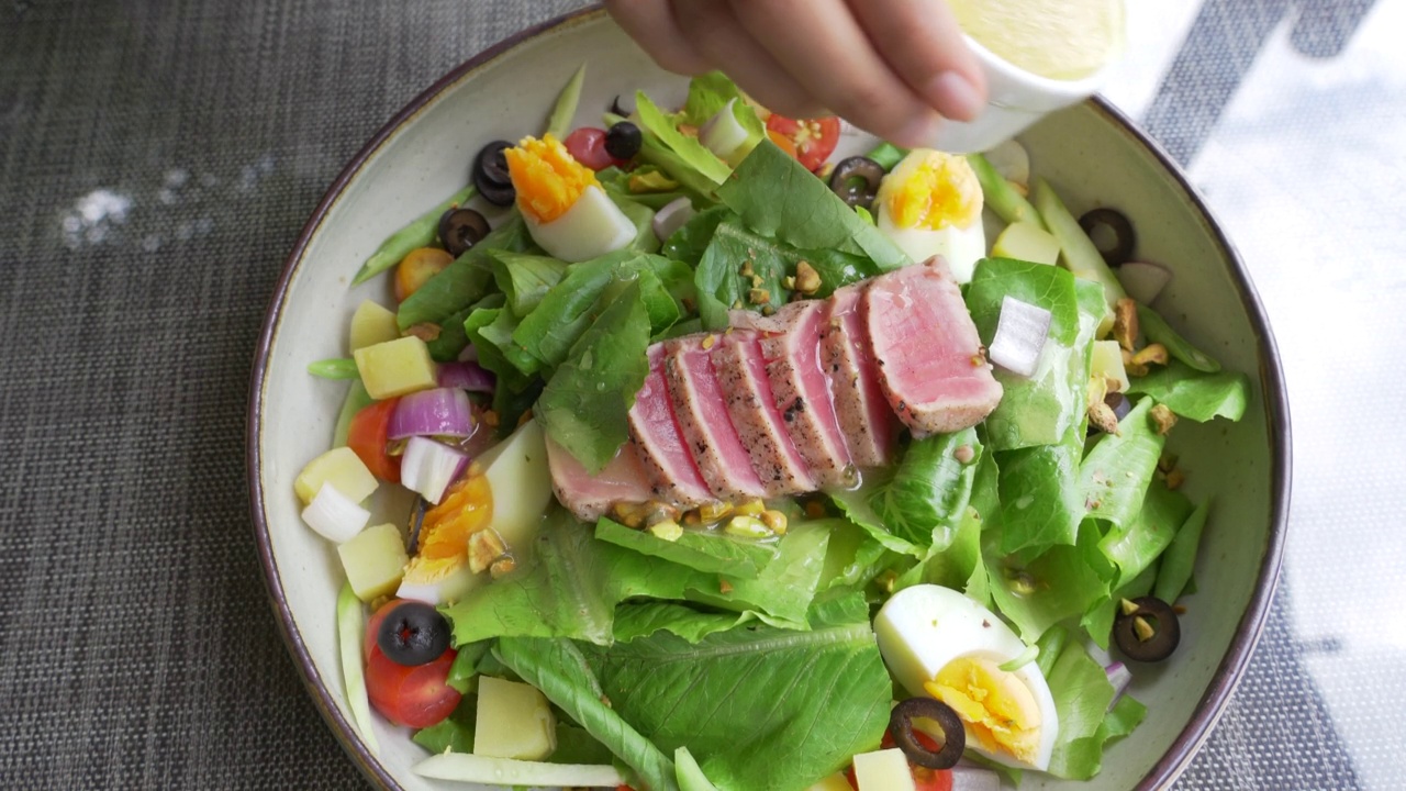 俯视图混合金枪鱼沙拉蔬菜在盘子里。意大利色拉。视频下载