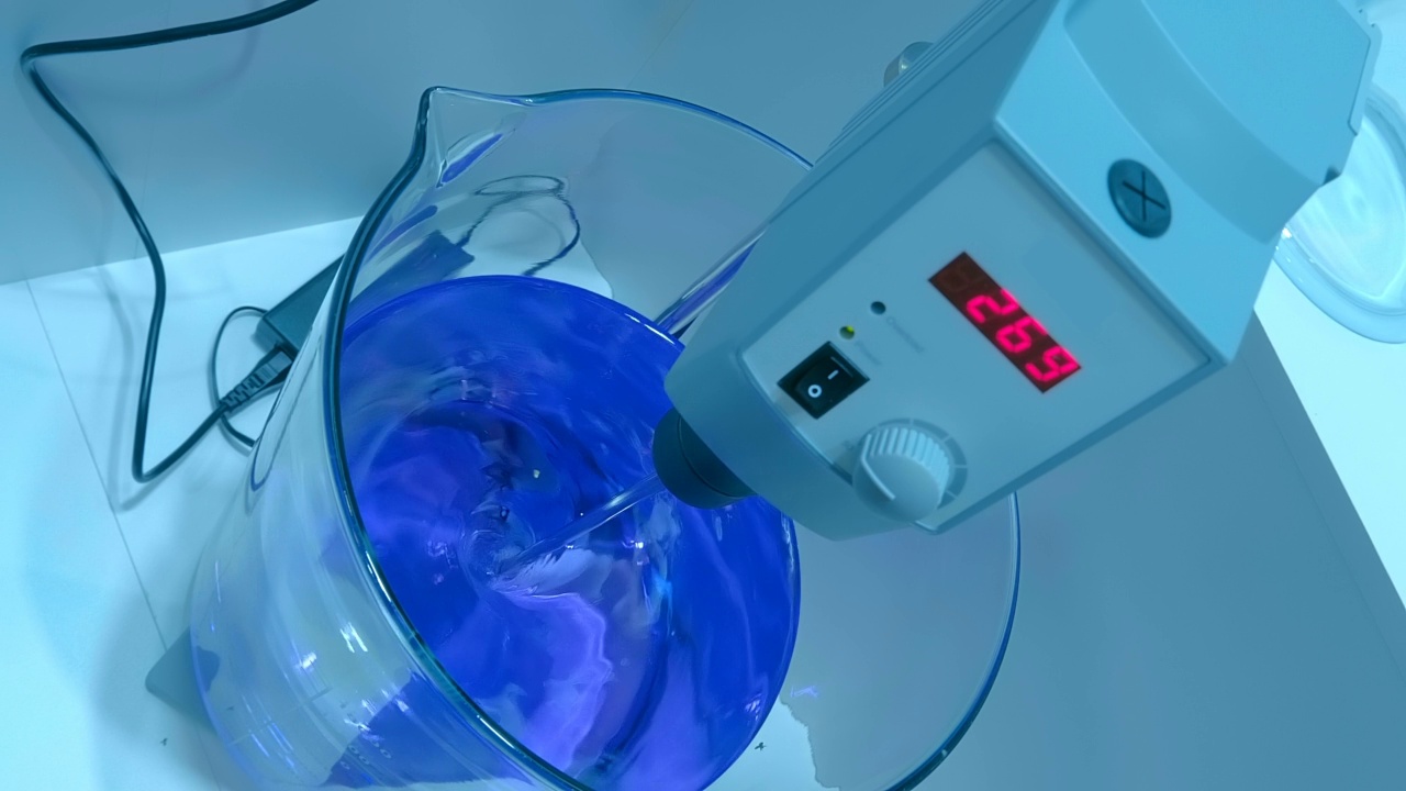 实验室的电动混合器在玻璃容器中混合产品的解决方案视频素材