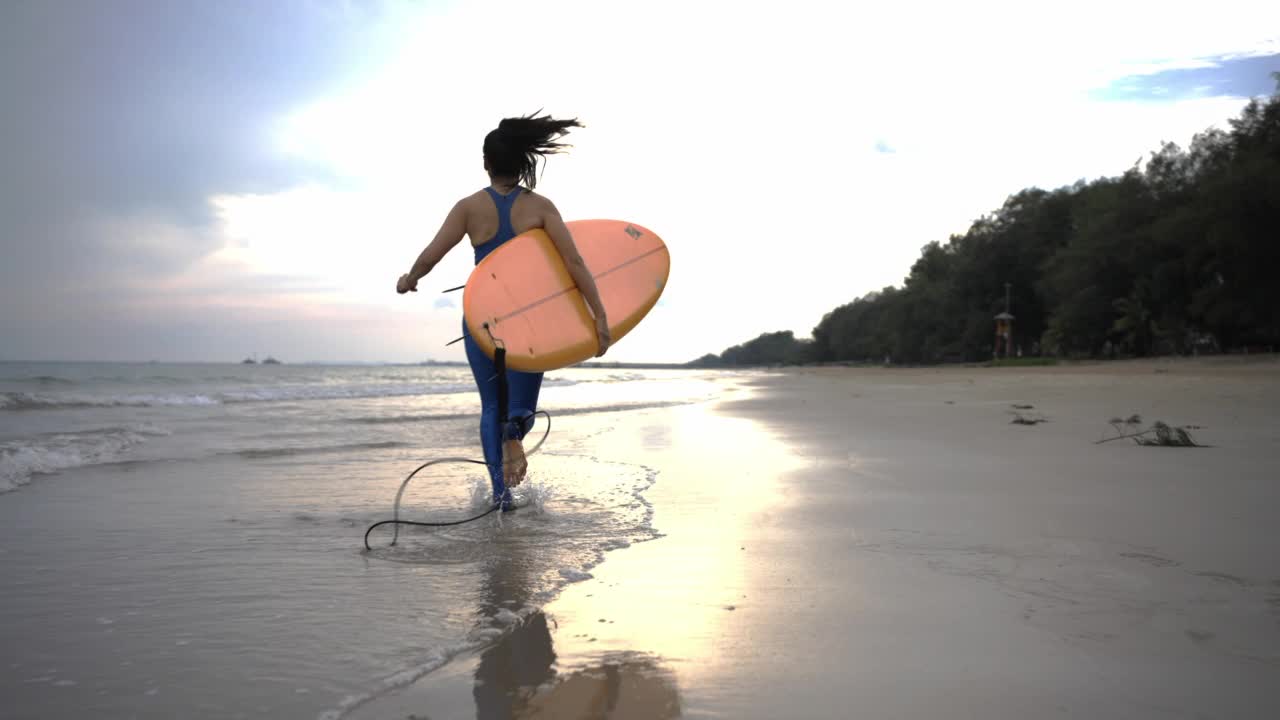 亚洲女子冲浪享受夏天冲浪板在海滩上，泰国。视频素材