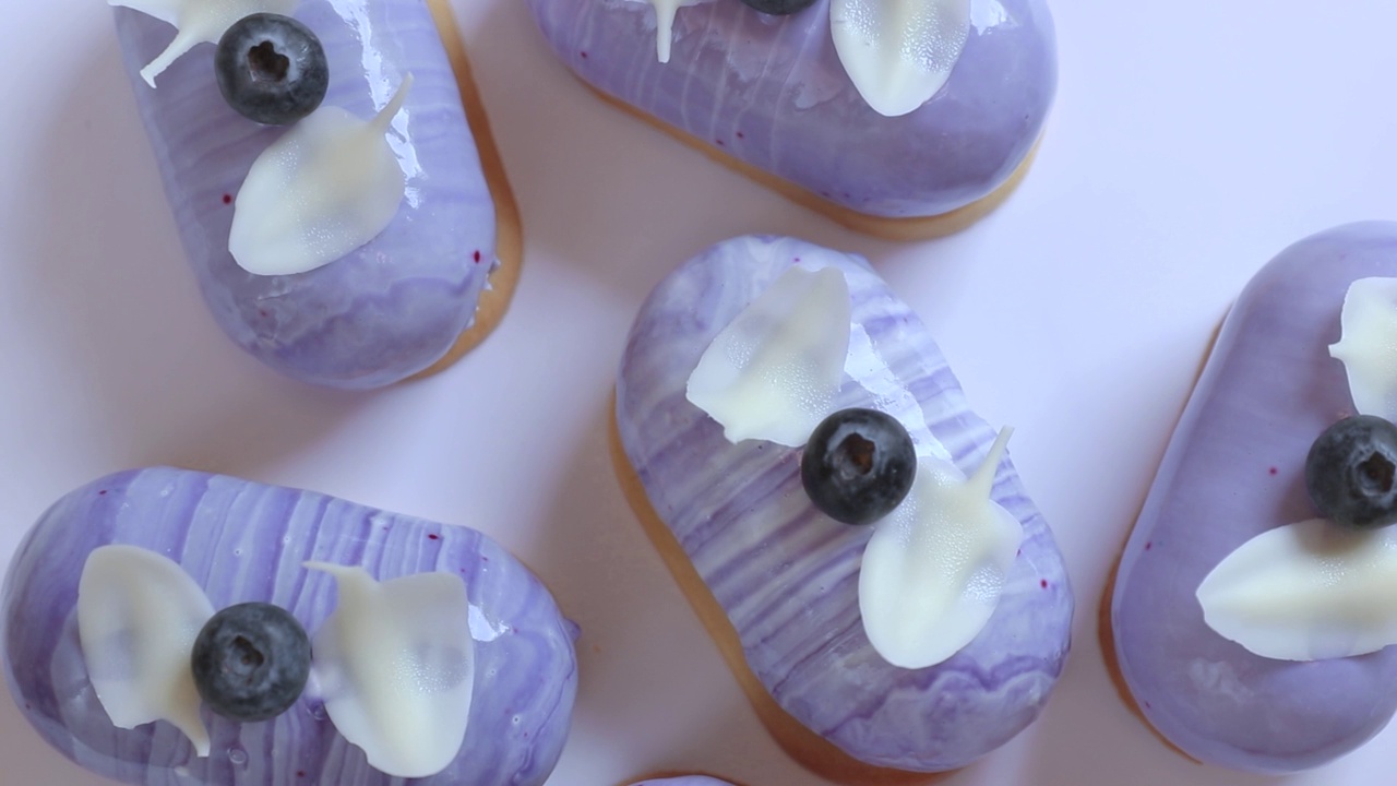 许多紫色蛋糕装饰奶油和蓝莓旋转俯视图视频下载