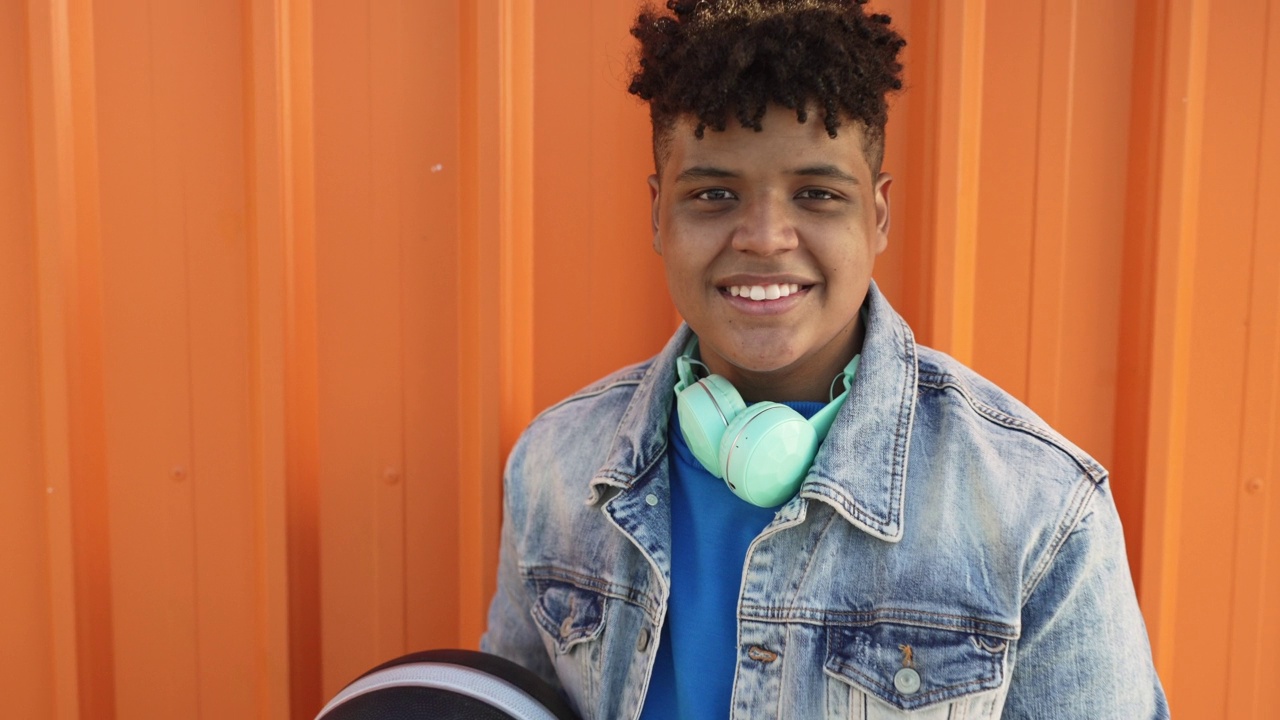一个微笑的十几岁男孩的肖像以橙色为背景视频下载
