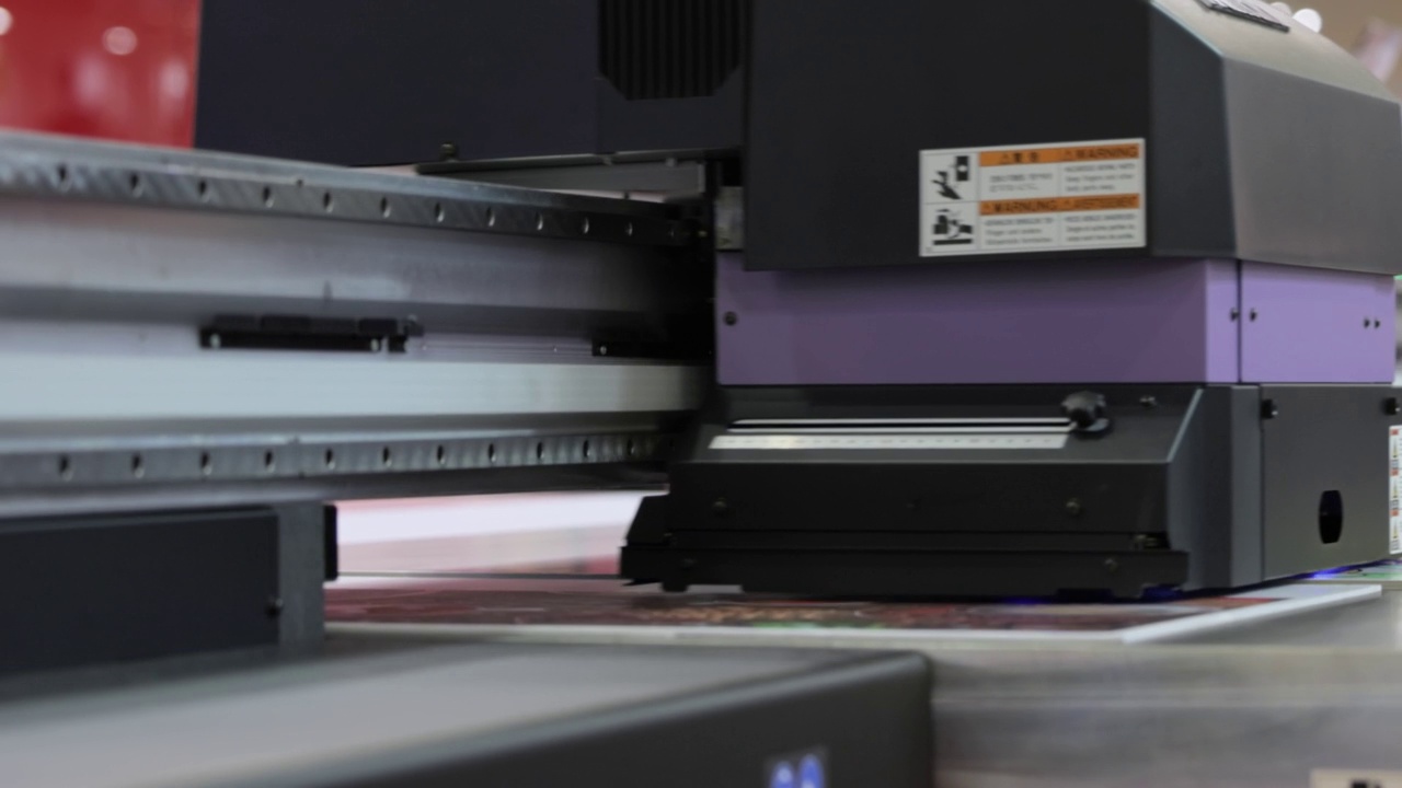 现代数字大型UV打印机。印刷生产技术。UV钉扎是将低强度的紫外线照射到UV可固化油墨上的过程视频素材