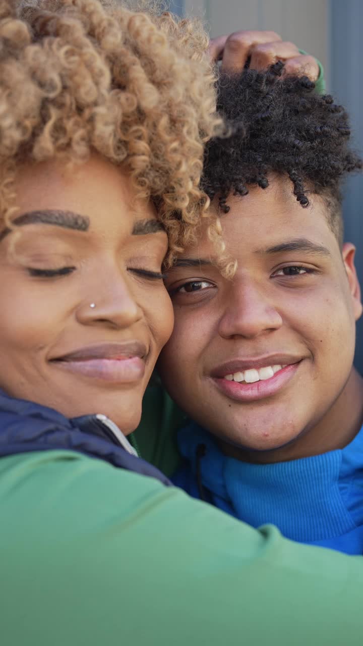一个十几岁的儿子和中年的母亲拥抱的肖像视频下载