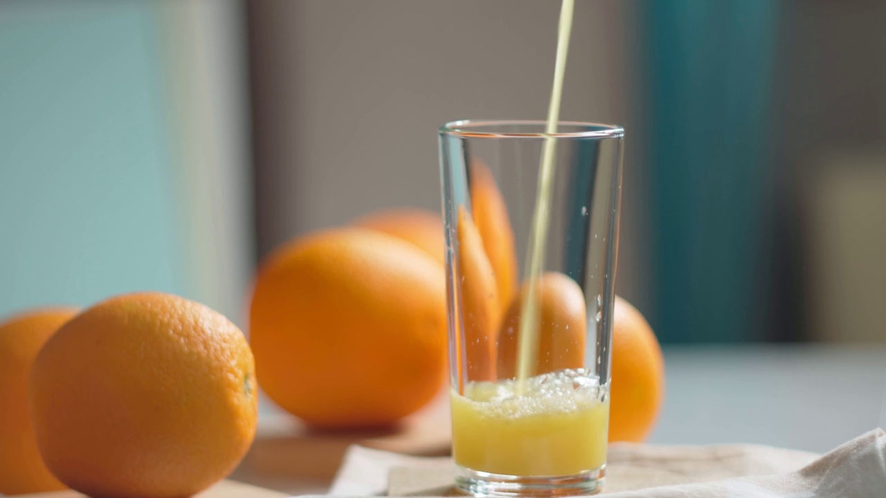 橙汁正往玻璃杯里倒。健康的素食。维生素的食物。成熟的橘子。视频素材