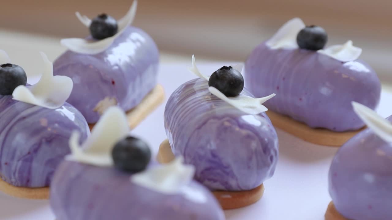 许多紫色蛋糕装饰奶油和蓝莓旋转侧视图视频下载
