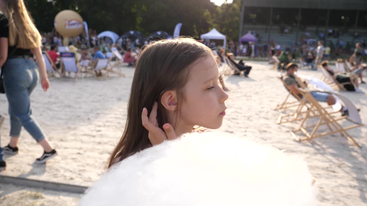 在一个城市的露天美食节上，小女孩喜欢吃甜甜的棉花糖视频下载