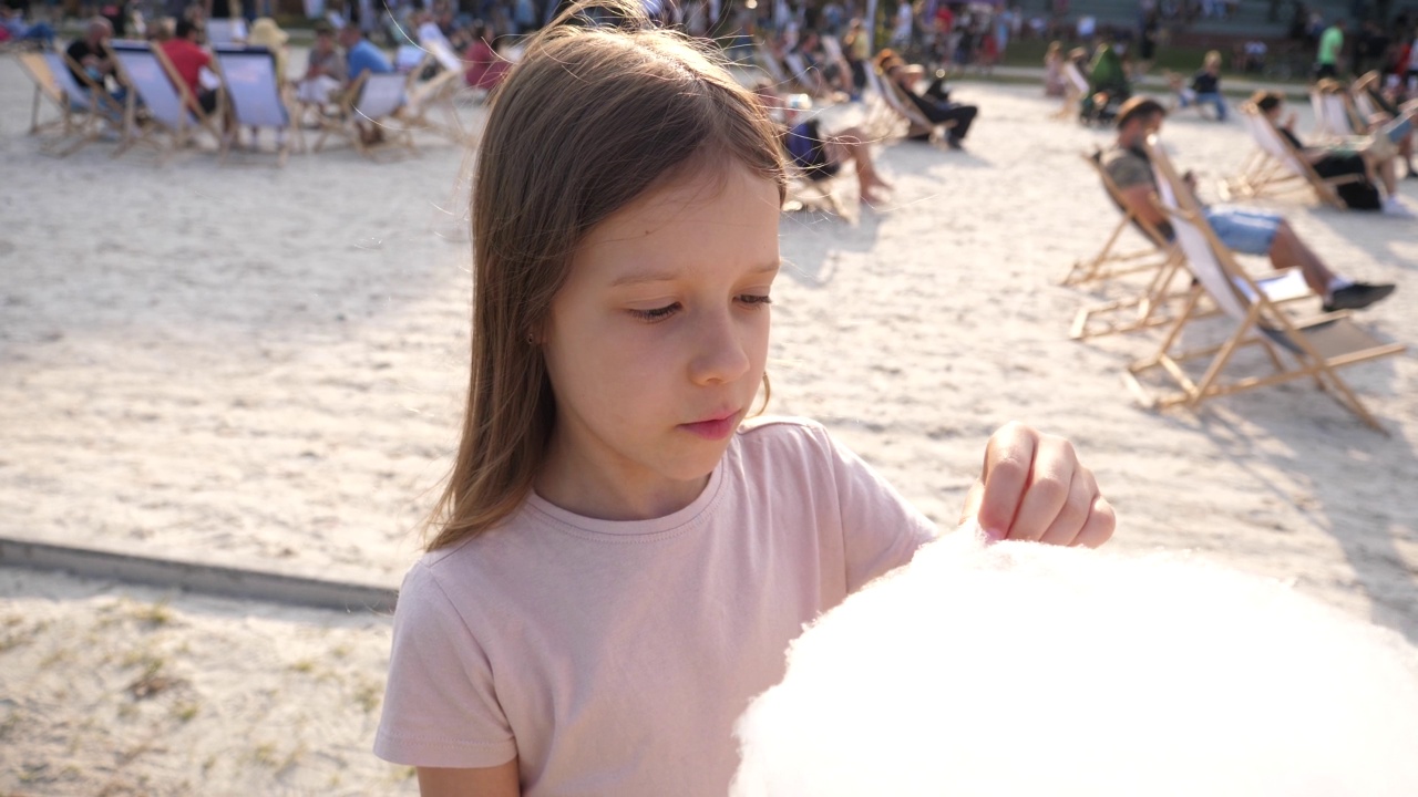 在一个城市的露天美食节上，小女孩喜欢吃甜甜的棉花糖视频下载
