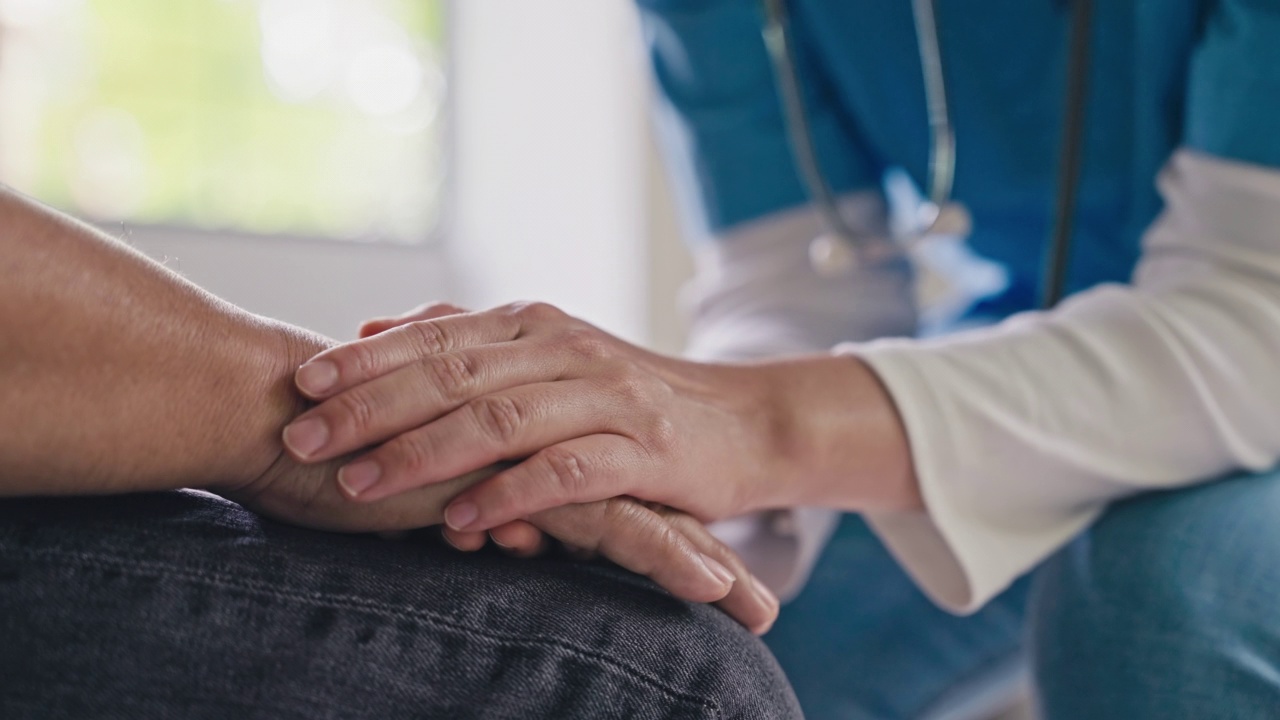 女医生或护士握着老年男性病人的手，特写视频素材