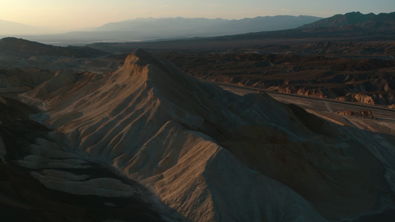 华丽的近距离全景无人机的古老岩层上升在死亡谷的日出视频下载