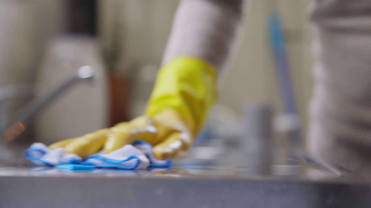 特写女人在橡胶手套清洁厨房柜台视频素材