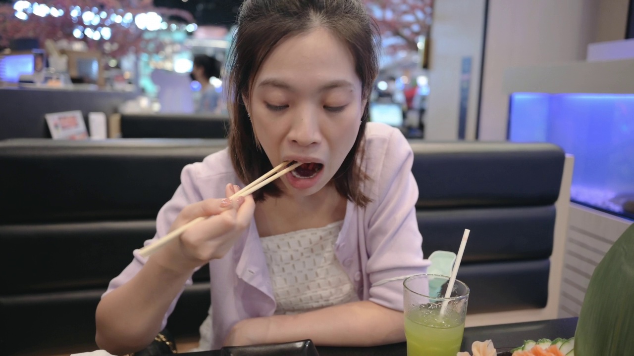 在泰国曼谷的一家日本餐厅，亚洲Y世代在豪华菜单上享用日式料理搭配什锦寿司、海鲜新鲜生鱼片视频素材