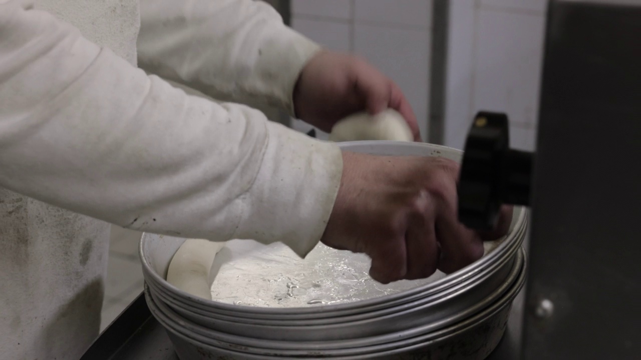 面团机，在生产线上弹出面团，同时面包师观察整个过程视频素材