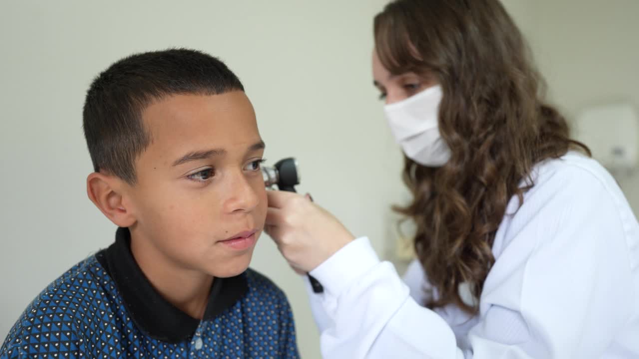 医生正在用耳镜检查男孩的耳朵视频下载