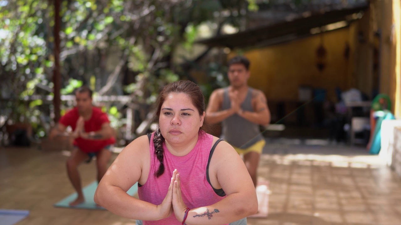年轻女子在瑜伽课上伸展身体视频素材