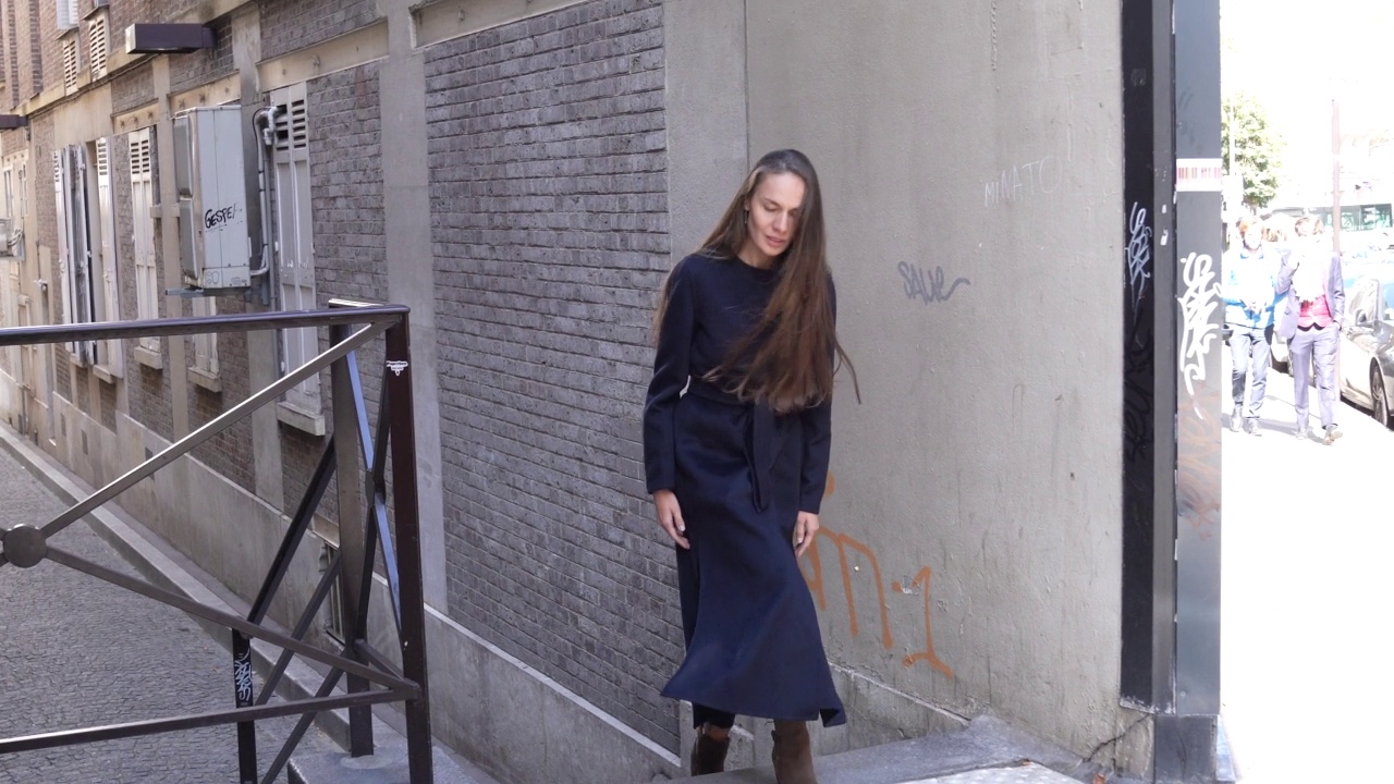 拍摄一个女人走在一小段户外楼梯，巴黎，法国，白天视频素材