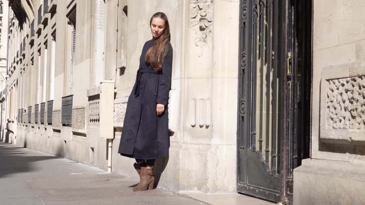 拍摄于法国巴黎，白天，一名女子靠墙站立视频素材