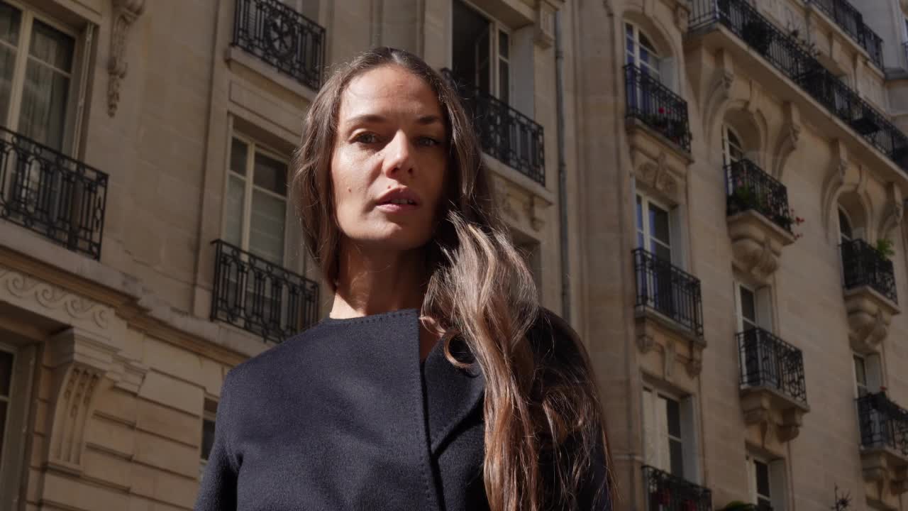 一个女人站在法国巴黎大街上的中景，白天视频素材