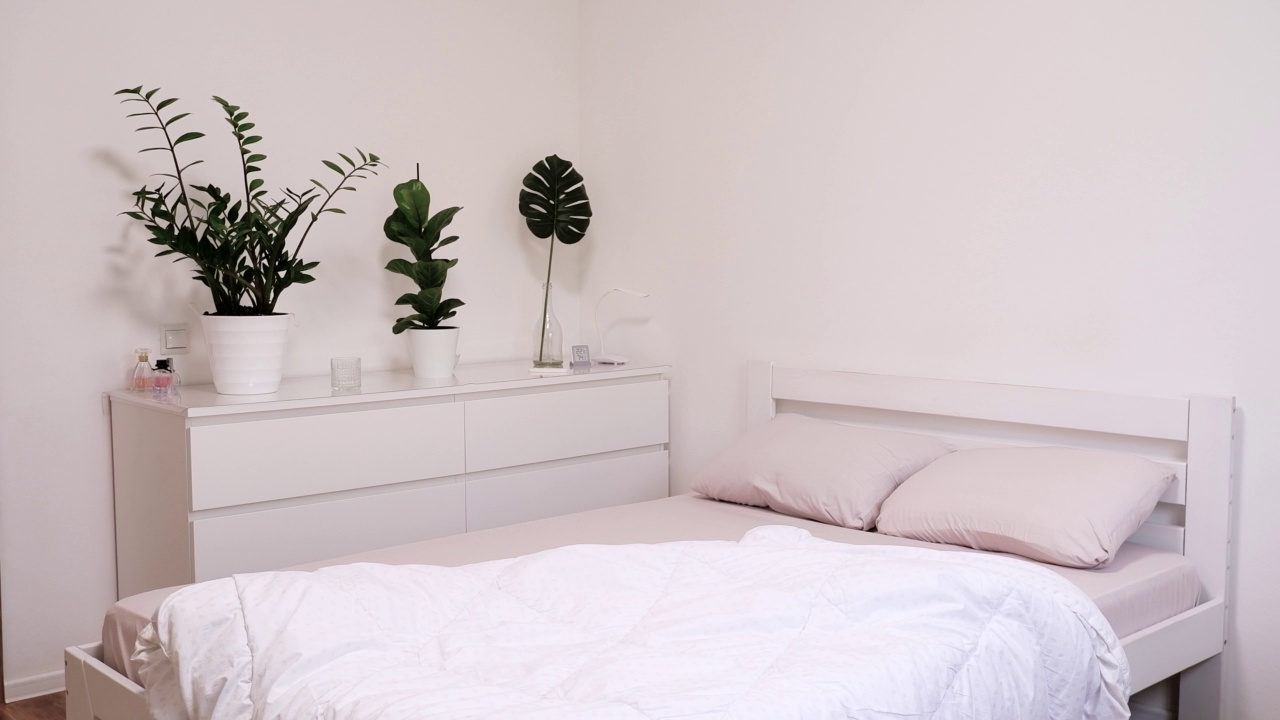 白色的毯子落在床上。在卧室里更换床单和亚麻布。漂亮明亮的现代风格的房间视频下载